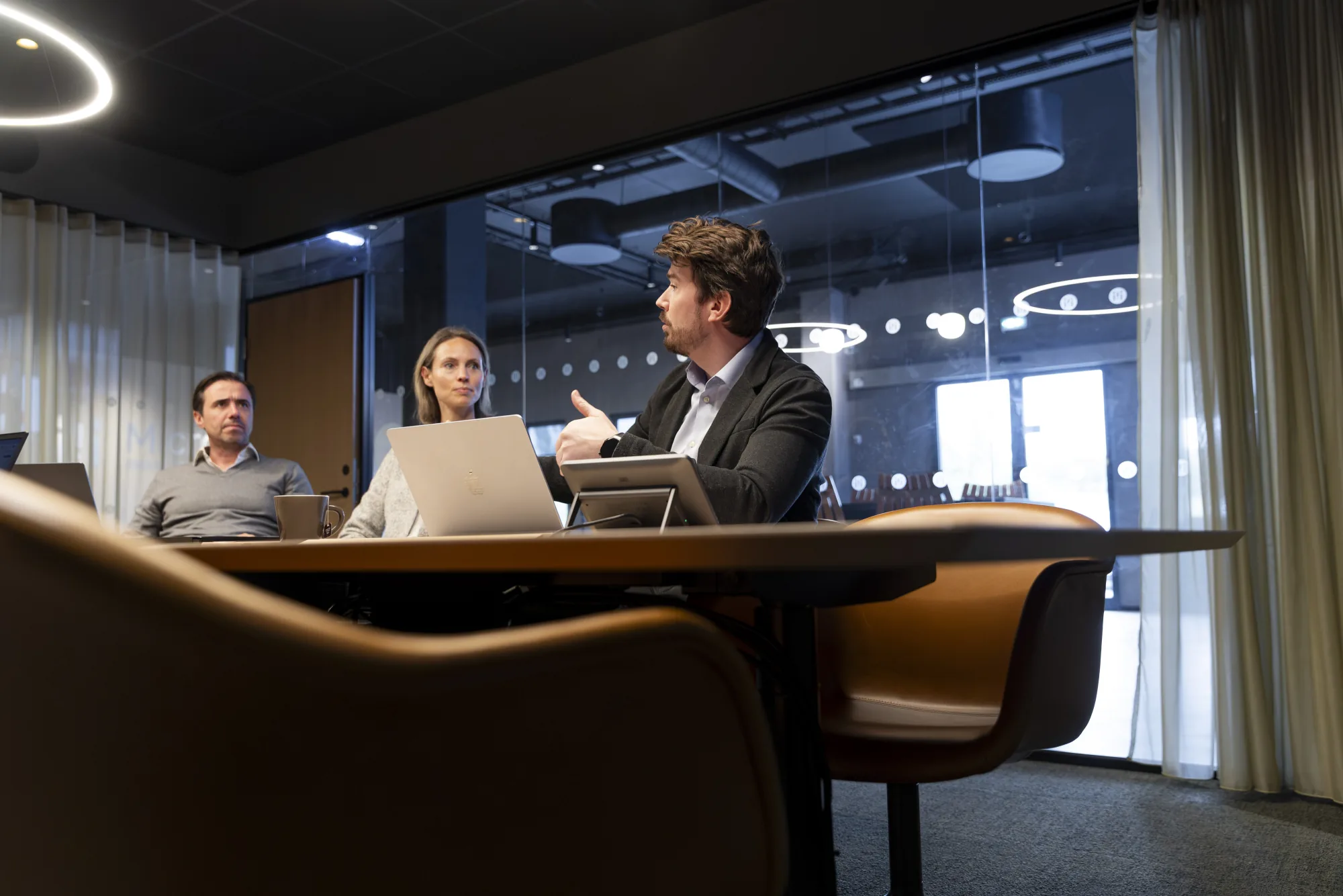 Microlog team in a meeting with customers in a glass-walled meeting room.