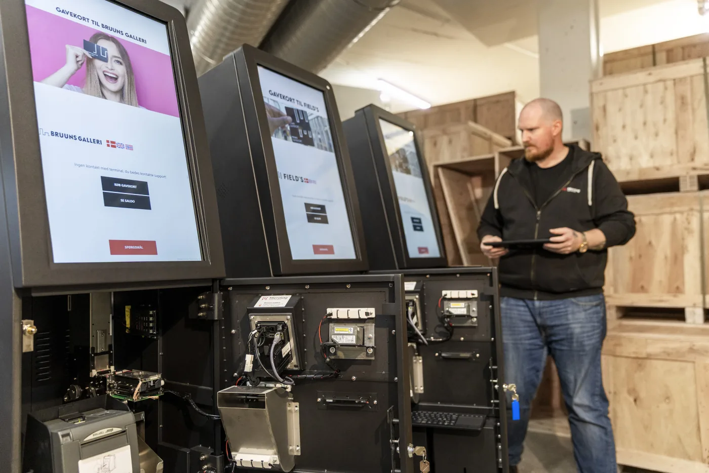 Microlog technician servicing gift card kiosks in the workshop.